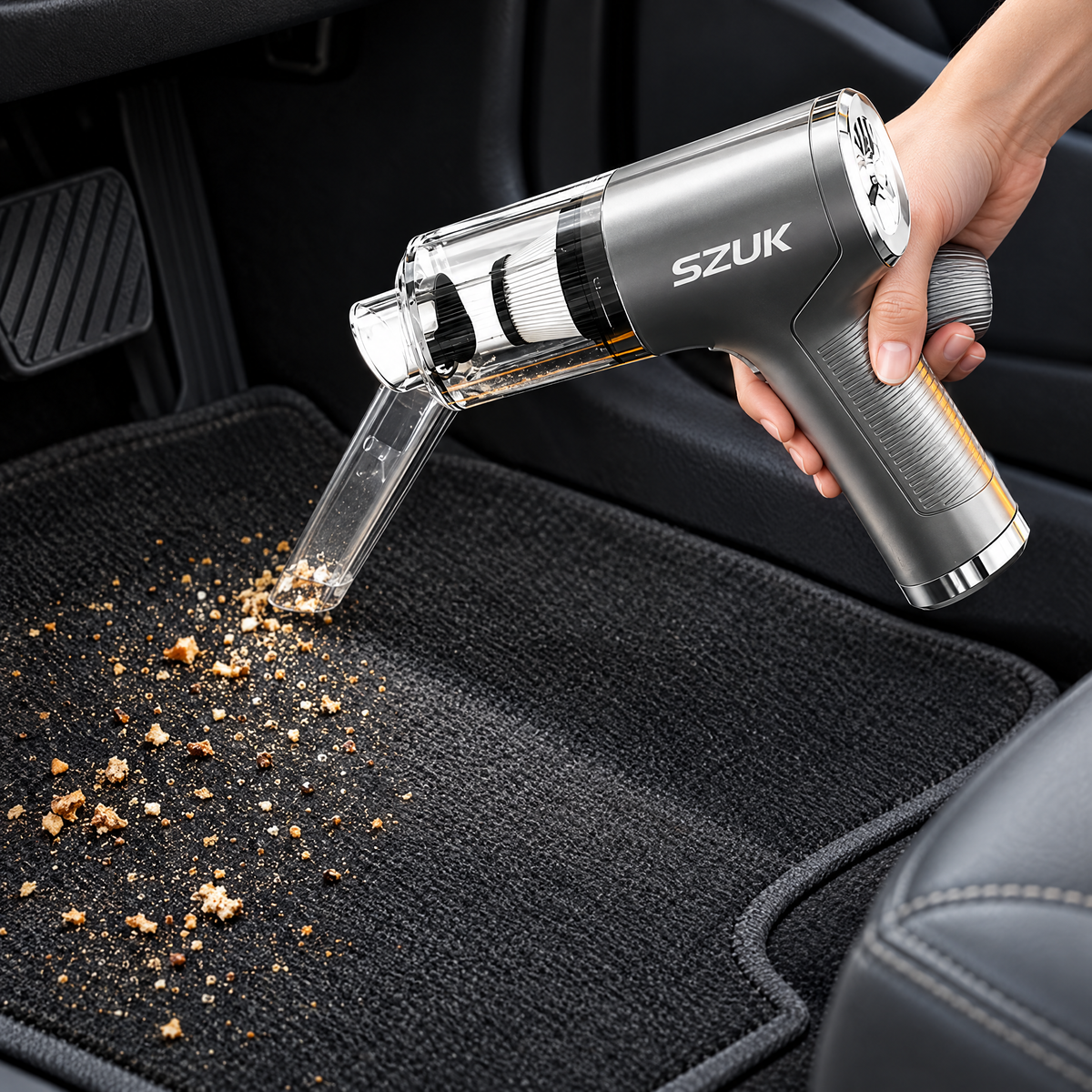 Handheld car vacuum cleaning crumbs from a car floor mat